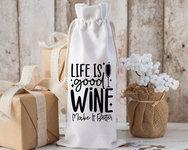 May include: White fabric wine bottle bag with black text that reads "Life is good wine. Make it better."