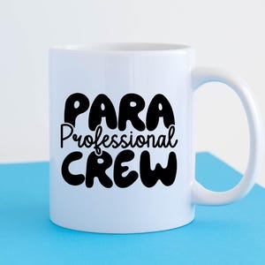 May include: White ceramic mug with a black design that says "Para Professional Crew".