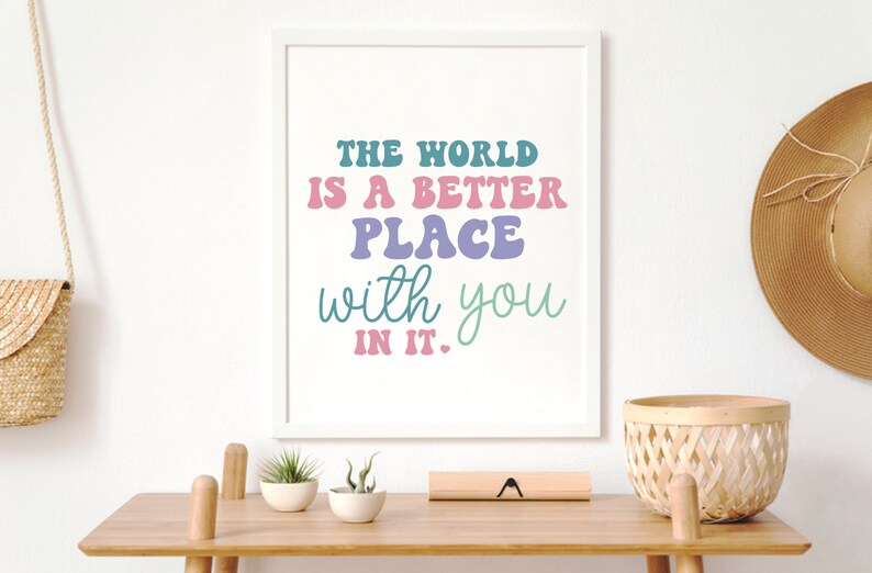 May include: A white framed print with the text "The world is a better place with you in it." The text is in a colorful, retro font.