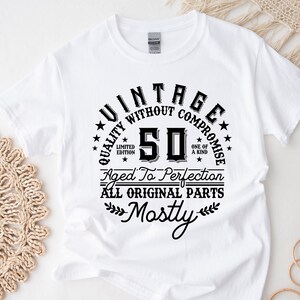 May include: White t-shirt with black text that reads "Vintage Quality Without Compromise 50 Aged To Perfection All Original Parts Mostly".