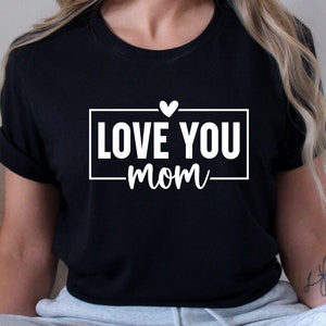 May include: Black t-shirt with white text that reads "LOVE YOU mom" with a small white heart above the text.