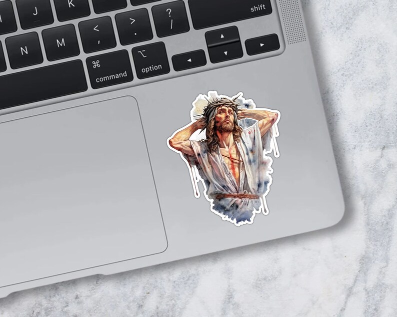 May include: A sticker featuring a watercolor painting of a man with a crown of thorns on his head. He is wearing a white robe and has a pained expression on his face.