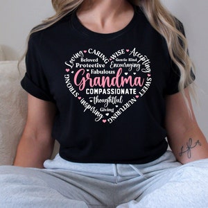 May include: Black t-shirt with a pink heart design that says "Grandma" surrounded by words describing her personality, such as "loving", "caring", "wise", "accepting", "strong", "inspiring", "compassionate", "thoughtful", "giving", "nurturing", "sweet", "gentle kind", "encouraging", "fabulous", "protective", and "beloved".