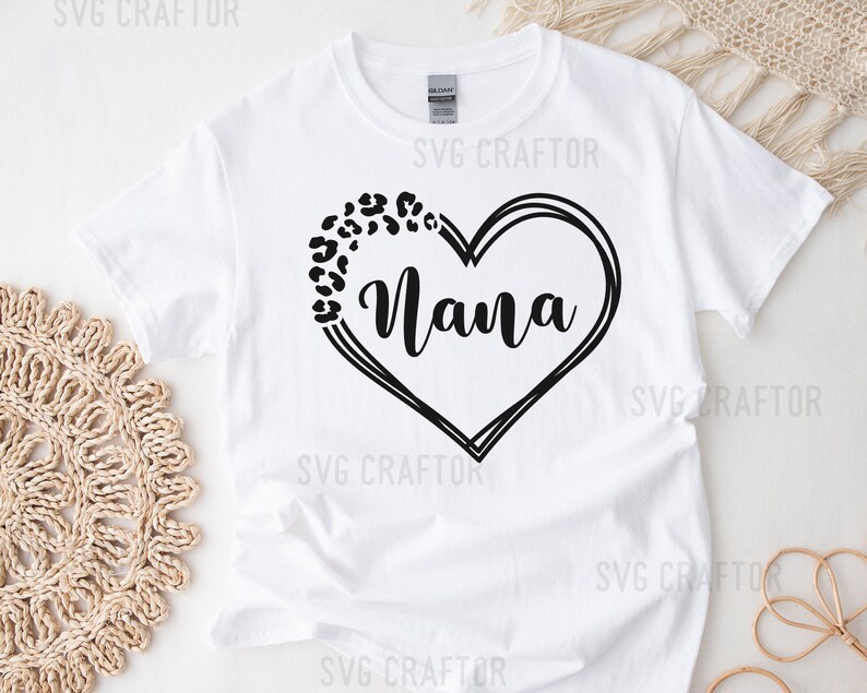 May include: White t-shirt with a black heart design featuring the word "Nana" and a leopard print pattern.