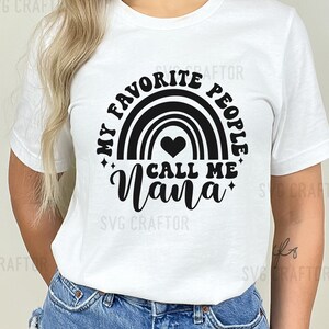 May include: White t-shirt with a black graphic design featuring a rainbow with a heart and the text "My Favorite People Call Me Nana".