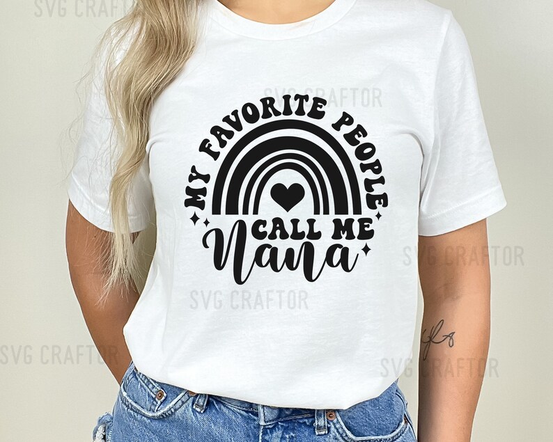 May include: White t-shirt with a black graphic design featuring a rainbow with a heart and the text "My Favorite People Call Me Nana".