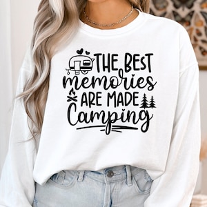 May include: White long-sleeve shirt with black text that reads "The Best Memories Are Made Camping" with a camper, campfire, and trees graphic.