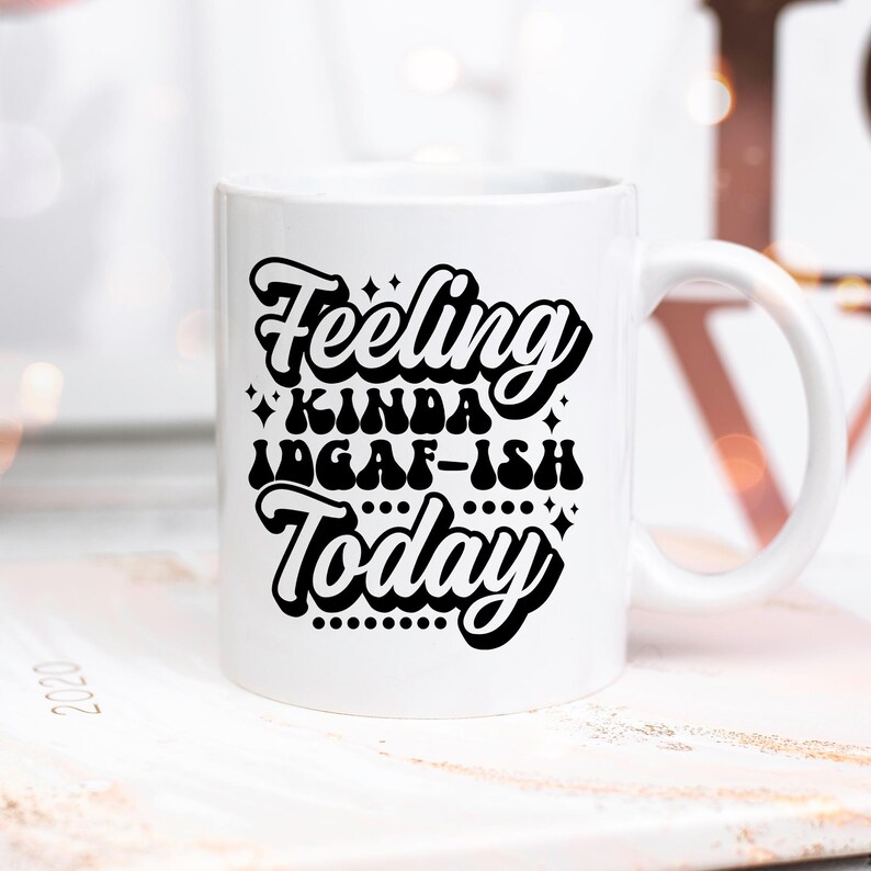 May include: White ceramic coffee mug with a black graphic that reads "Feeling Kinda IDGAF-ish Today".