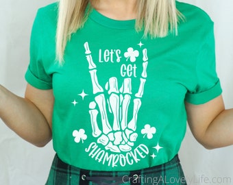 May include: Green t-shirt with a white skeleton hand design that says "Let's get shamrocked".