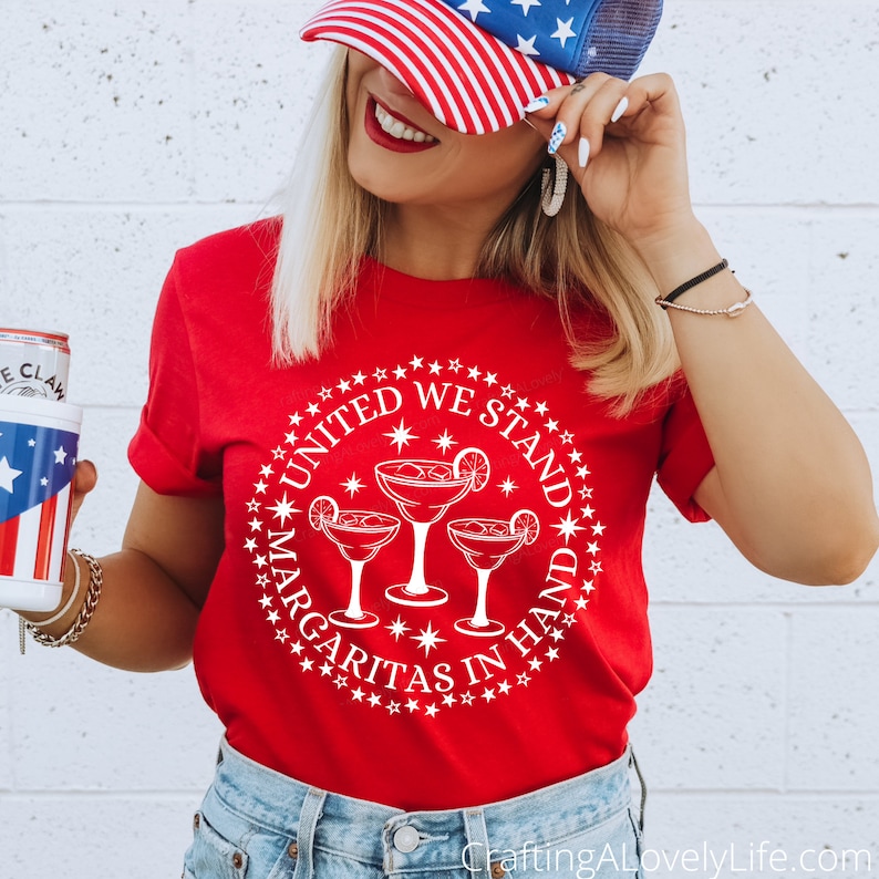 May include: Red t-shirt with a white circle design featuring three margarita glasses and the text "United We Stand Margaritas In Hand".