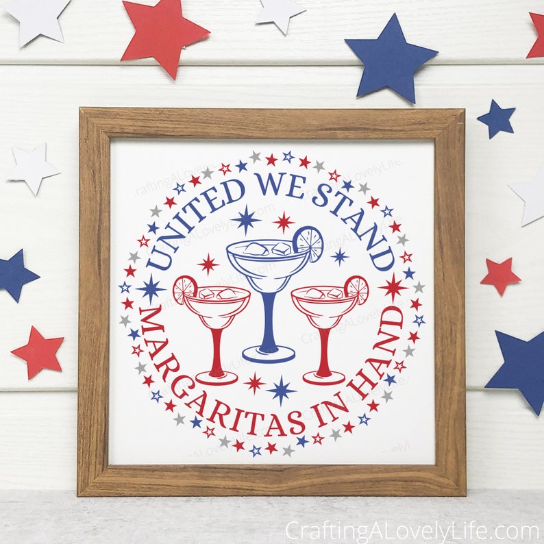 May include: A framed print with a white background and a blue and red circle design. The circle features three margarita glasses with a lime wedge and ice. The text "United We Stand Margaritas In Hand" is written in a circle around the glasses.