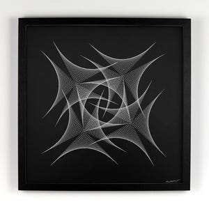 May include: Black framed artwork featuring a white geometric design. The artwork has a square shape and is mounted on a white wall. The design is a complex pattern of intersecting lines and shapes, creating a visually striking piece.