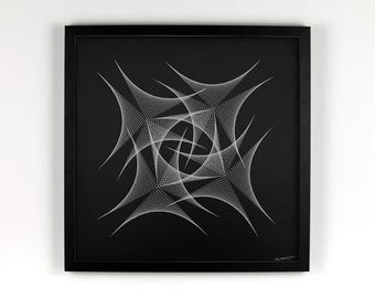 Op de afbeelding: Zwart omlijst kunstwerk met een wit geometrisch ontwerp. Het kunstwerk is aan een witte muur bevestigd. Het ontwerp is een complex patroon van elkaar kruisende lijnen en vormen, waardoor een visueel opvallend kunstwerk ontstaat.
