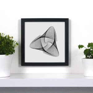 Puede incluir: Un cuadro negro con una impresión artística abstracta en blanco y negro con un diseño geométrico. La obra de arte se exhibe en una estantería blanca, flanqueada por dos plantas en macetas blancas. El estilo es minimalista.