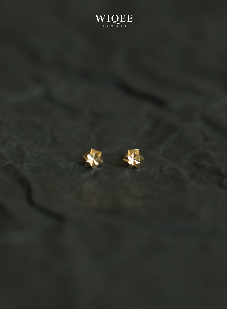 Puede incluir: Un par de pendientes de estrella de oro. Los pendientes son peque&ntilde;os y delicados, y tienen un dise&ntilde;o geom&eacute;trico.