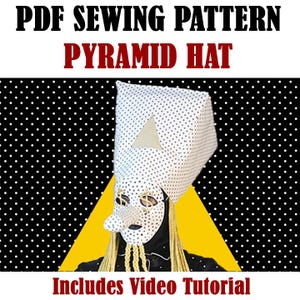 May include: A PDF sewing pattern for a pyramid hat. The hat is white with black polka dots, featuring a tall, pointed structure, a long nose, and dollar sign eye cutouts. The design includes long, light-colored braided fringe accents.