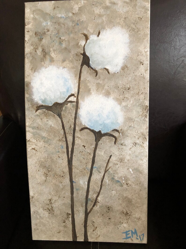 May include: A painting of three white cotton bolls on brown stems against a textured beige background. The artist's signature "EM 17" is in the bottom right corner.