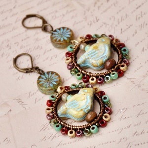 Boho Antique Gold Bird Drop/Dangle Earrings Made With A Blue/Cream Czech Bird And Tan, Red, Green, And Blue Seed beads. With A Blue Flower.