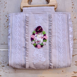 Bolso de mano o cartera estilo shabby chic o boho. Fabricado con tela de lino beige y estampado estilo flapper rodeado de flores rosas y burdeos hechas a mano.