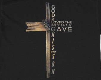 Puede incluir: Camiseta negra con un gráfico de una cruz de madera y el texto "Dios amó tanto al mundo que dio a su Hijo unigénito".
