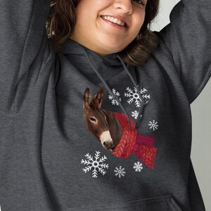 May include: A dark gray hooded sweatshirt with a white snowflake pattern and a brown donkey wearing a red scarf.