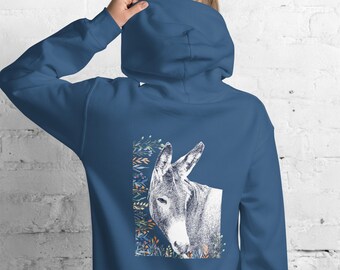 Puede incluir: Una sudadera con capucha azul con un gráfico blanco de la cabeza de un burro asomándose detrás de un diseño floral.