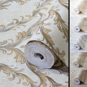 May include: A roll of wallpaper featuring a cream-colored background with a repeating metallic gold and silver damask-style leaf pattern. The surface has a textured finish, and the design is shown in multiple color variations in the side panel.