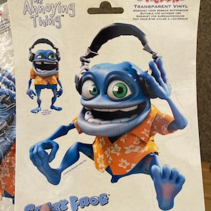 Könnte beinhalten: Zwei Aufkleber mit einer blauen Comic-Frosch, die Kopfhörer und ein Hawaii-Hemd trägt. Die Aufkleber sind mit "The Annoying Thing" und "Crazy Frog" beschriftet.