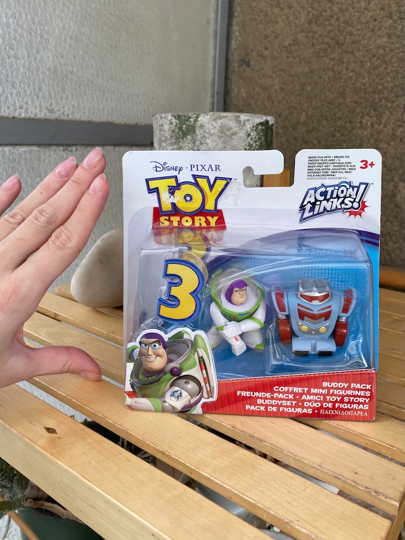 May include: Toy Story 3 Action Links Buddy Pack featuring Buzz Lightyear and a robot. The packaging is blue and red with the Toy Story logo and the Action Links logo.