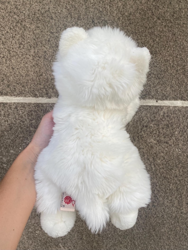 May include: White plush toy resembling a polar bear with a red tag that says "Jellycat" on the back.