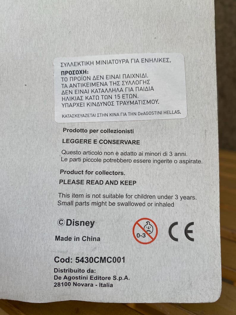 May include: A white box with a warning label in Greek and English. The label states that the product is not a toy and is not suitable for children under 3 years old. The box also includes the Disney logo, a CE mark, and the text "Made in China".