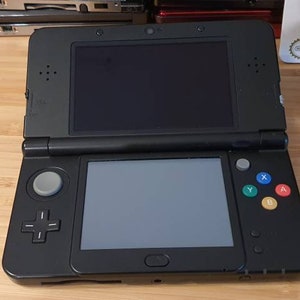 New Nintendo 3ds black edition. With free games.Original.Super condition. Vintage game with charger. .Region free . 5000 games image 1