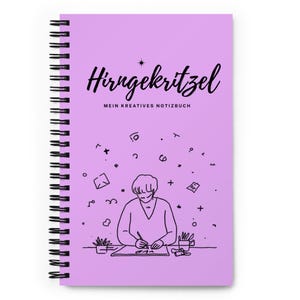 Op de afbeelding: Een paars spiraalgebonden notitieboek met de Duitse tekst "Hirngekritzel" in zwart script op de kaft, met "MEIN KREATIVES NOTIZBUCH" eronder. Een zwarte lijntekening van een schetsende persoon staat onderaan.