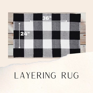 May include: Black and white checkered rug with a 36 inch by 24 inch size. The rug is made of a soft, plush material and is perfect for layering over other rugs.