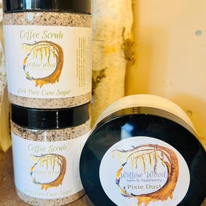 May include: Three jars of body scrub and powder. Two jars are labeled "Coffee Scrub" with "Willow Wood" branding and "With Pure Cane Sugar." The third jar is labeled "Pixie Dust" with "Willow Wood" branding.