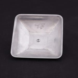 May include: A silver square-shaped metal lid with a small screw in the center and a logo that reads "WARE BROS. PAT. APPL'D FOR."
