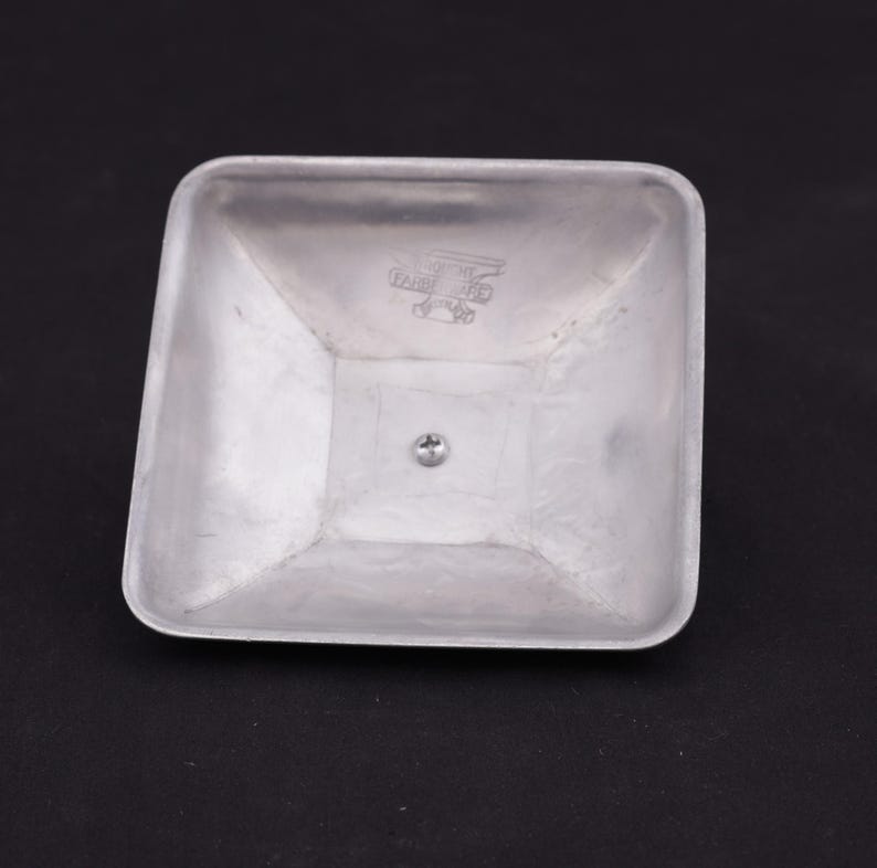 May include: A silver square-shaped metal lid with a small screw in the center and a logo that reads "WARE BROS. PAT. APPL'D FOR."