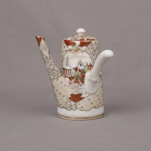 May include: A white ceramic mug with a black handle and the text "But First, Coffee" in a handwritten style. The mug is on a white surface. The mug is likely 11 ounces.