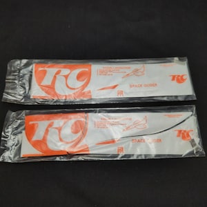 May include: Two packages of RC Space Glider model airplanes. Each package has a white background with the RC logo in orange and the words "Space Glider" printed in black.