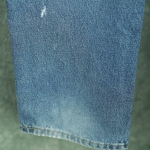 Peut inclure: Gros plan sur l'ourlet inf&eacute;rieur d'un jean bleu. Le tissu est d'un bleu clair d&eacute;lav&eacute; avec une texture subtile.