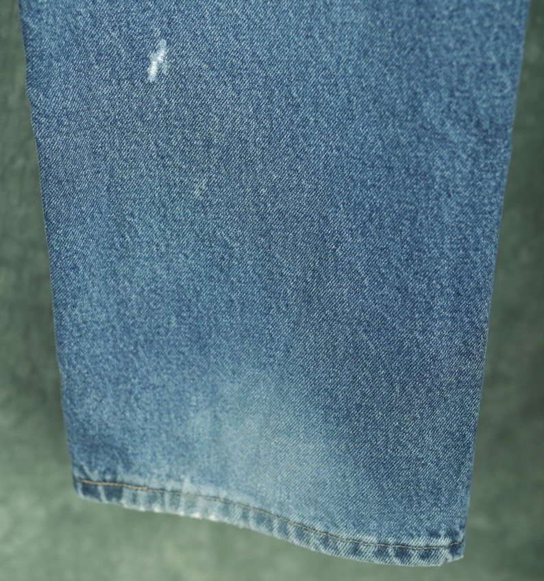 Peut inclure: Gros plan sur l'ourlet inf&eacute;rieur d'un jean bleu. Le tissu est d'un bleu clair d&eacute;lav&eacute; avec une texture subtile.