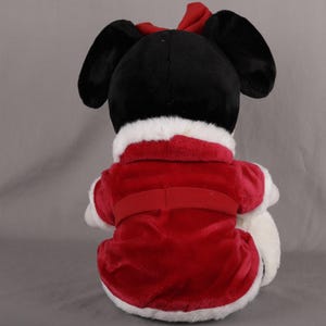 Pu&ograve; includere: Un peluche con testa nera, grandi orecchie e un fiocco rosso. Indossa un cappotto di velluto rosso con finiture bianche e cintura abbinata. Un giocattolo festivo per le festivit&agrave;.