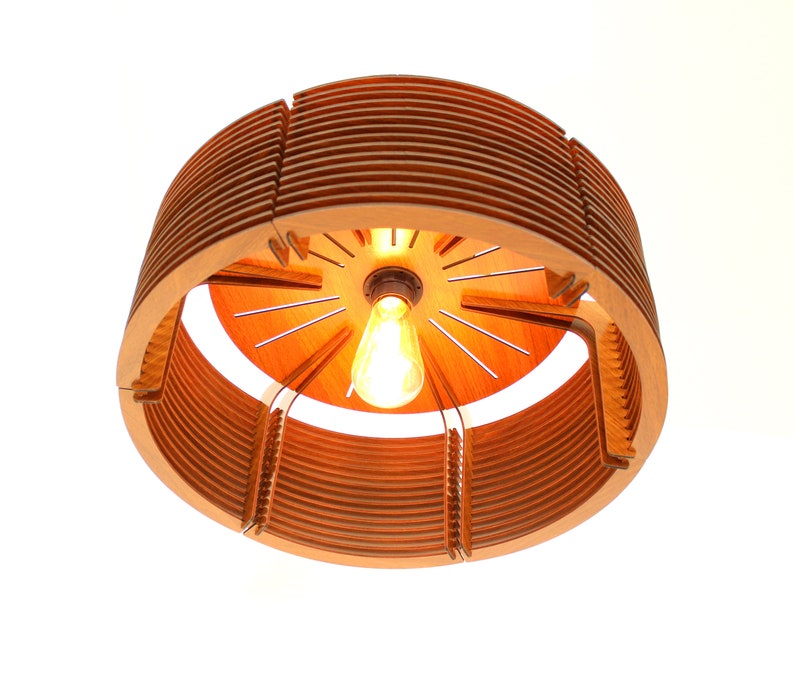 Puede incluir: Una l&aacute;mpara colgante de madera con una luz c&aacute;lida y acogedora. El dise&ntilde;o circular presenta listones de madera en capas y una bombilla central. La l&aacute;mpara est&aacute; suspendida del techo, mostrando su dise&ntilde;o &uacute;nico y moderno.