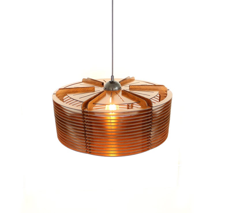 Puede incluir: Una moderna l&aacute;mpara colgante circular, hecha de madera marr&oacute;n claro en capas. El dise&ntilde;o presenta una serie de listones de madera horizontales alrededor de la circunferencia, con una secci&oacute;n superior decorativa. Una sola bombilla es visible en el interior, emitiendo un brillo c&aacute;lido.