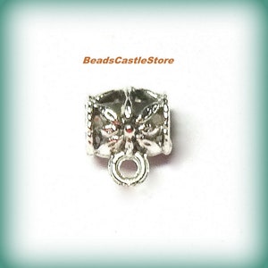 May include: Silver metal bead cap with a decorative floral design and a small loop at the bottom.