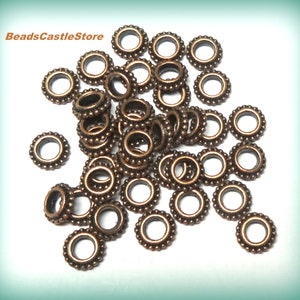 May include: A pile of 30 copper-colored jump rings with a beaded edge. The jump rings are approximately 6mm in diameter.