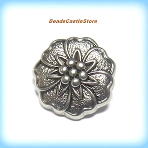 May include: Silver metal flower button with a textured surface and a raised center with five round beads.
