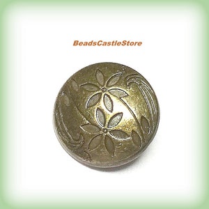 May include: A gold-toned metal button with a floral design. The button has a raised, embossed design of stylized flowers and leaves.