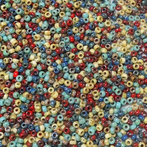 May include: A large assortment of colorful seed beads in shades of blue, red, yellow, and brown. The beads are small and round, and they are perfect for jewelry making or other craft projects.