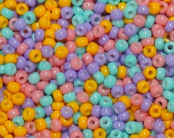 Może przedstawiać: Zbliżenie na dużą ilość małych, okrągłych koralików w pastelowych kolorach. Koraliki są mieszanką jasnoniebieskiego, jasnoróżowego i żółtego.